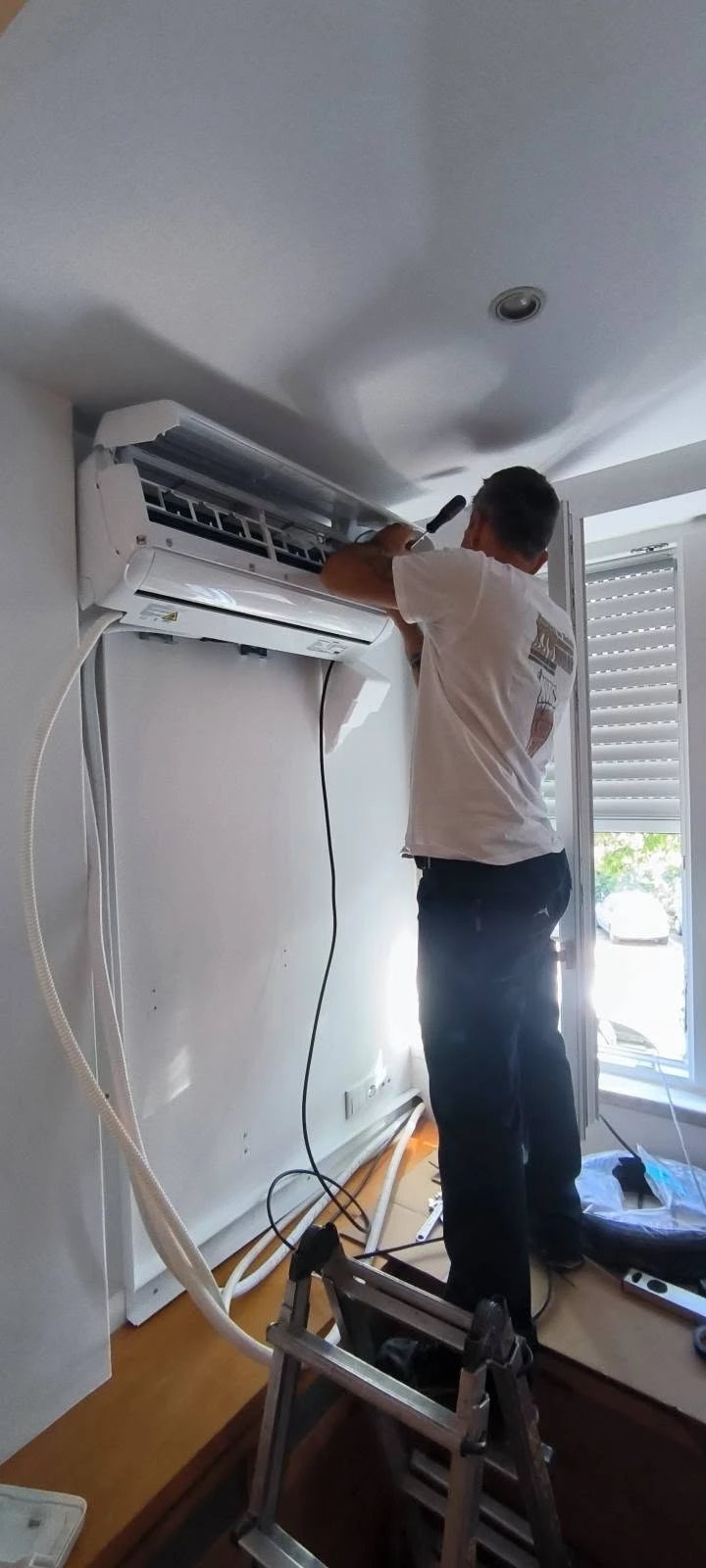 Técnico da PM Projeto a instalar um ar condicionado